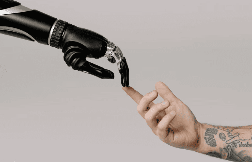 AI in marketing and the impact to work, showing one robotic hand touching a human hand as in michelangelo's painting.